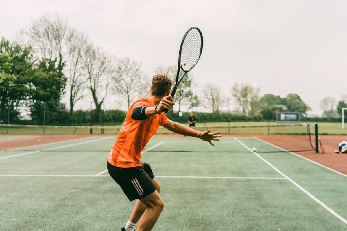 Tennis player training on an outdoor hard court